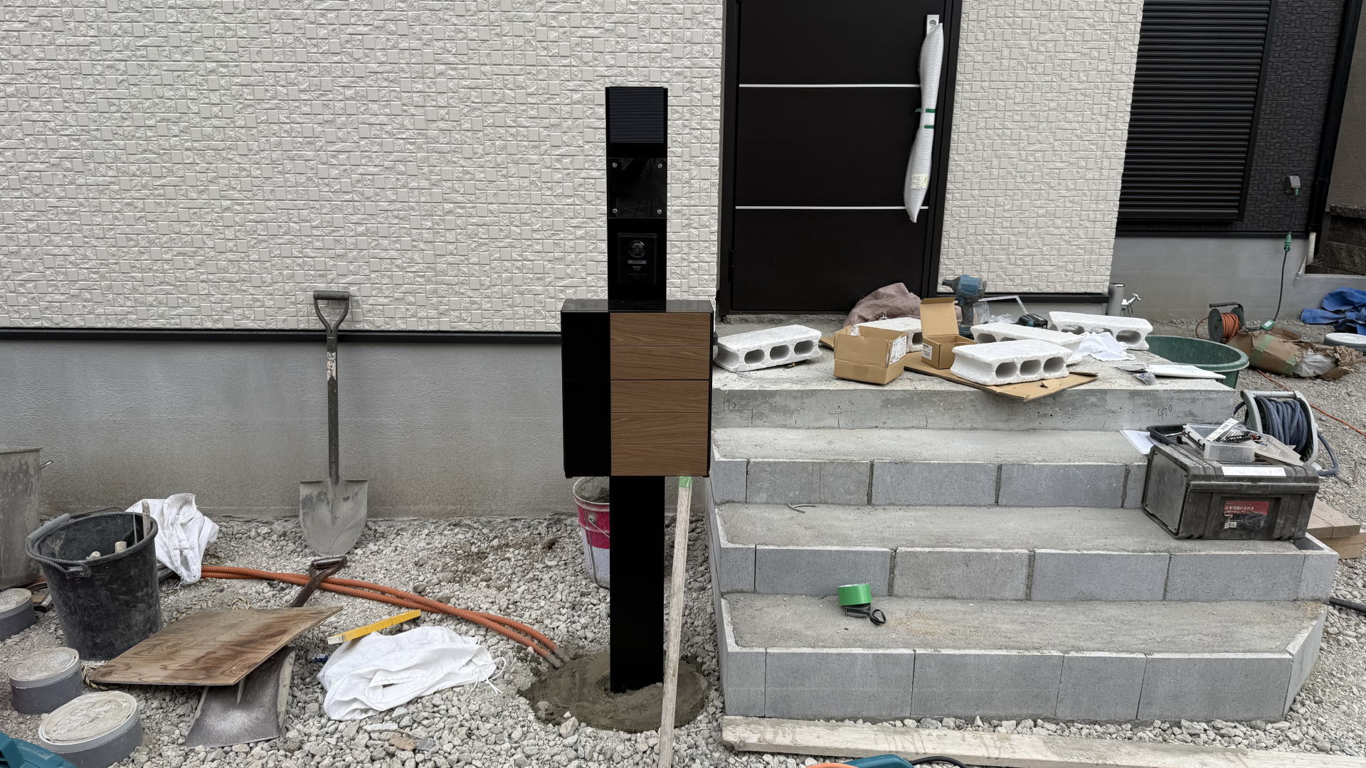 高槻市M様邸　アプローチ　機能門柱： ・LIXIL　機能門柱FP/ブラック　エクスポストグレイスウッド/ブラック＆チェリーウッド　ガラスサイン/クリア